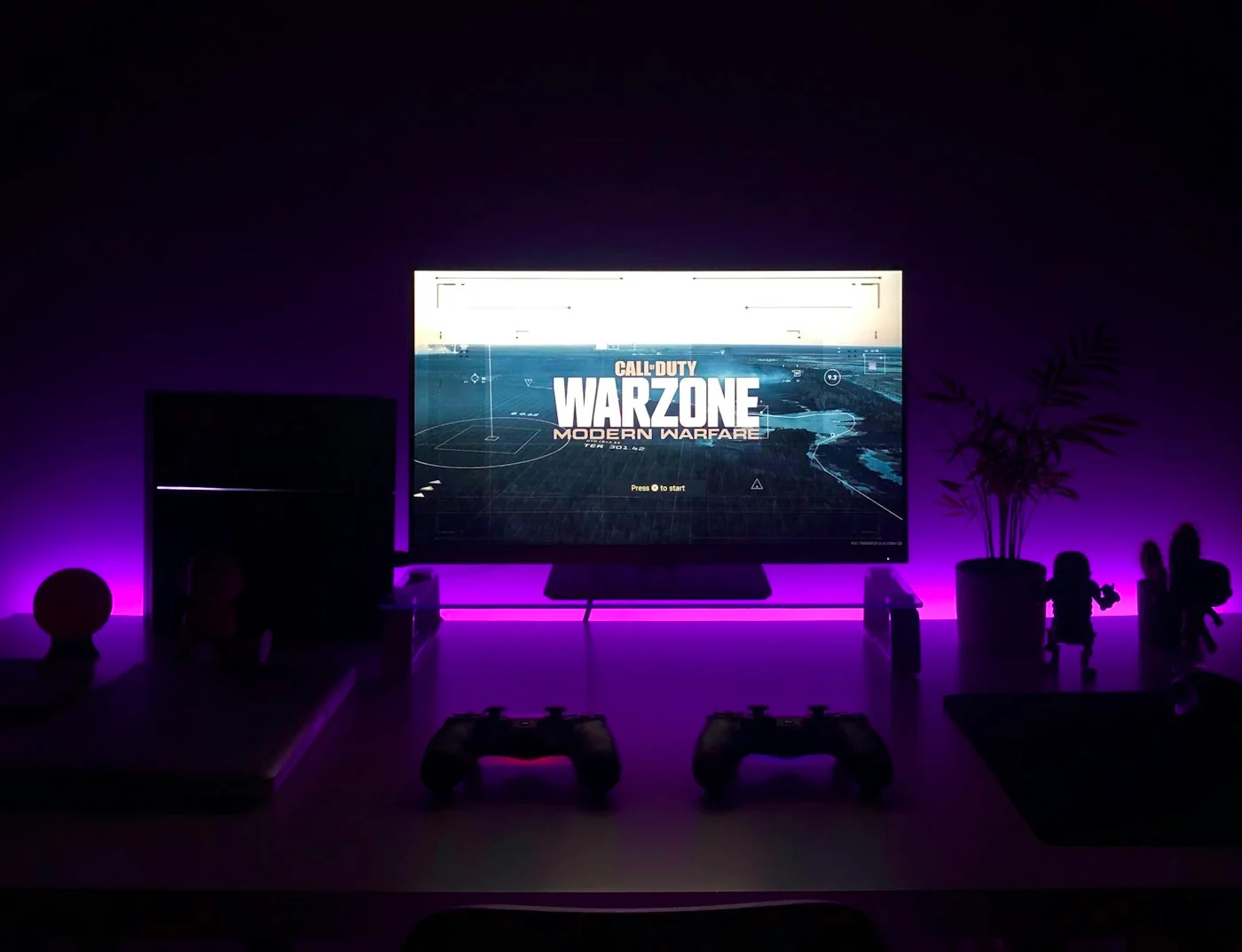Clean modern gaming desk with monitor, PC, and controllers in a premium dark setup